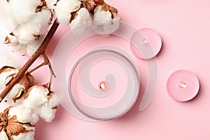 Scented candles and cotton on pink background