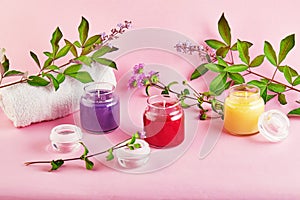 Scented candles for Spa and home with green leaves on a pink background