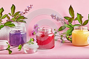 Scented candles for Spa and home with green leaves on a pink background photo