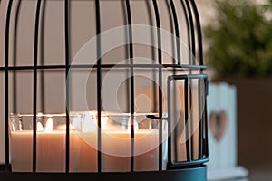 Scented lit candles in a decorative cage