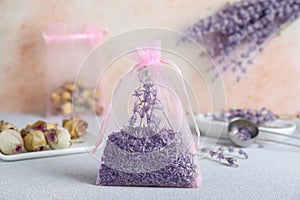Scented sachet with dried lavender flowers on light gray table