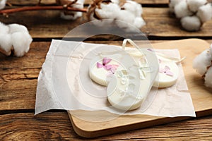 Scented sachets and cotton flowers on wooden table