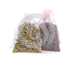 Scented sachets with dried flowers on white background