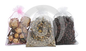 Scented sachets with dried roses, chamomile flowers and coffee beans isolated on white