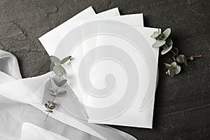 Scented sachets, eucalyptus branches and fabric on black table, flat lay