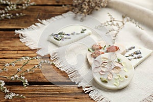 Scented sachets and flowers on wooden table