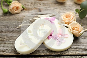 Scented sachets and flowers on wooden table