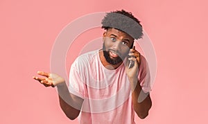 Sceptic african american man talking on mobile phone