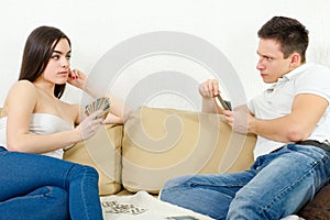 Sceptic young couple cheating each other in card game