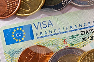 Schengen visa in the passport with a few coins. Issued by the French Embassy.