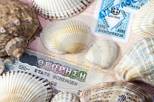 Schengen visa in the passport and sea shells