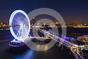 Scheveningen, the Hague illuminated ferris wheel on the pier at night under moonlight