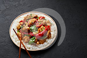 Schezwan Chicken or Dragon Chicken with basmati rice at black slate background