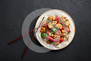 Schezwan Chicken or Dragon Chicken with basmati rice at black slate background