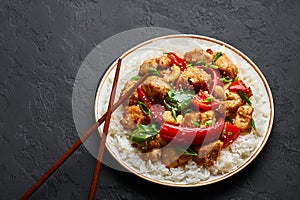 Schezwan Chicken or Dragon Chicken with basmati rice at black slate background