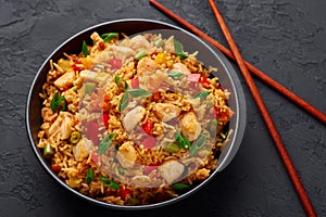 Schezwan Chicken Fried Rice in black bowl at dark slate background. indo-chinese cuisine dish