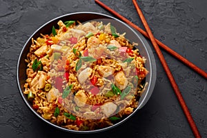 Schezwan Chicken Fried Rice in black bowl at dark slate background. indo-chinese cuisine dish photo