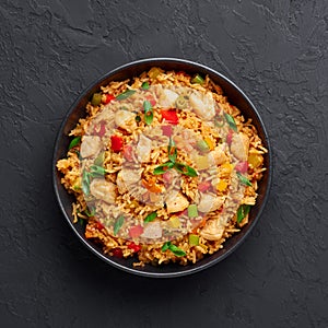 Schezwan Chicken Fried Rice in black bowl at dark slate background. indo-chinese cuisine dish