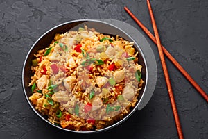 Schezwan Chicken Fried Rice in black bowl at dark slate background. indo-chinese cuisine dish