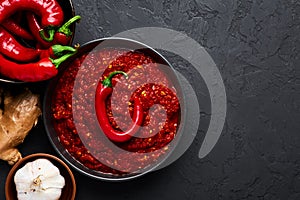 Schezwan Sauce in black bowl at dark background. Schezwan Sauce is Indo-chinese or Sichuan cuisine hot sauce with red chilli,