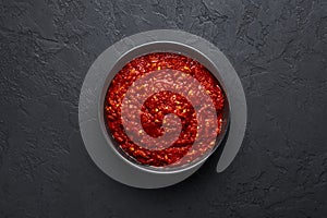 Schezwan Sauce in black bowl at dark background. Schezwan Sauce is Indo-chinese or Sichuan cuisine hot sauce with red chilli,