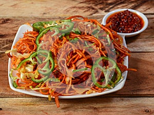 Schezwan Veg Noodles a popular indo-chinese dish made with noodles, vegetables and schezwan sauce, served over a rustic wooden