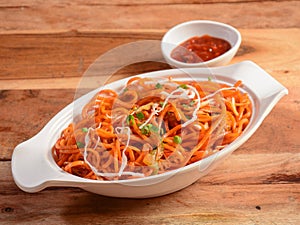 Schezwan Veg Noodles a popular indo-chinese dish made with noodles, vegetables and schezwan sauce, served over a rustic wooden