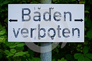 Schild an einem See mit den deutschen Worten Baden verboten