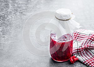 Schisandra jam in glass jar on gray background