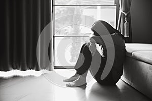 Schizophrenia with lonely and sad in mental health depression concept. Depressed woman sitting against floor at home with dark