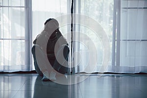 Schizophrenia with lonely and sad in mental health depression concept. Depressed woman sitting against floor at home with dark