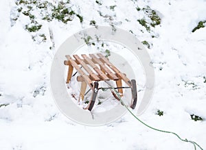 Schlitten Holz. Wooden vintage winter sled in the snow