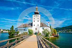 Schloss Ort castle near Traunsee, Austria. View of ancient castle with long bridge over lake. Famous tourist destination