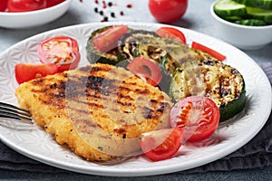 Schnitzel of chicken and zucchini cooked on the grill. Fresh tomatoes on a plate. Ready delicious dinner lunch