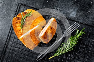 Schnitzel Cordon bleu fillet cutlet with ham and cheese. Black background. Top view