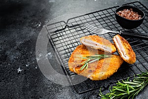 Schnitzel Cordon bleu fillet cutlet with ham and cheese. Black background. Top view. Copy space