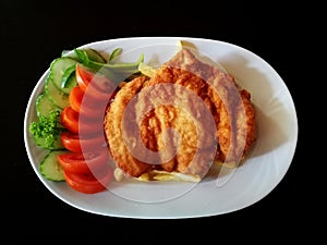 Schnitzel with fries, tartar souce and vegetables, on a white porcelain dish, meal for one people