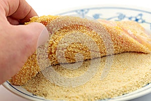 A schnitzel is rolled in breadcrumbs photo