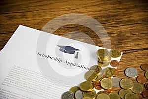 Scholarship application document contract form concept with money coin for grants scholarships education on wooden table