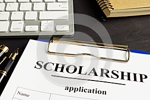 Scholarship application and money for education on a table.