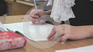 Schoogirl writes text in a notebook on a lesson