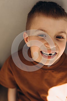 A school age boy shows the teeth that grow after the loss of milk teeth. Close-up portrait