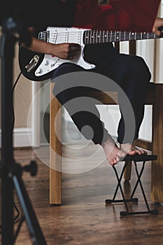 A school age boy strumming the guitar.