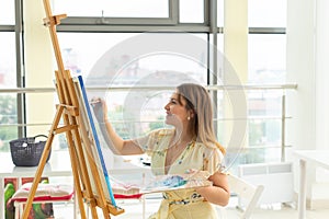School of art, college of arts, education for group of young students. Happy young woman smiling, girl learning to paint