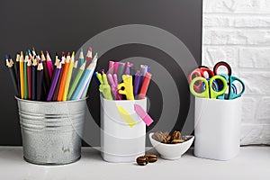 School background: a white brick wall with accessories, pencils, tetrads, scissors, an apple, pecans, a board for a