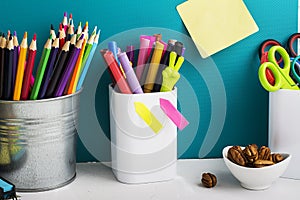 School background: a white brick wall with accessories, pencils, tetrads, scissors, an apple, pecans, a board for a