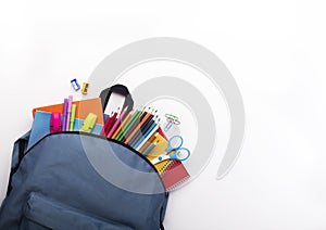 School backpack with colored stationery on white background