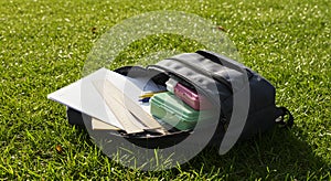 School Backpack Outdoors: Open Backpack with Supplies on Grass