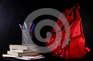 A school bag with a pen stand placed on the pile of books -Education concept