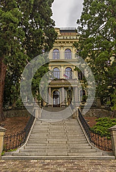 School in Banska Stiavnica town in cloudy day after rain with sequoia trees